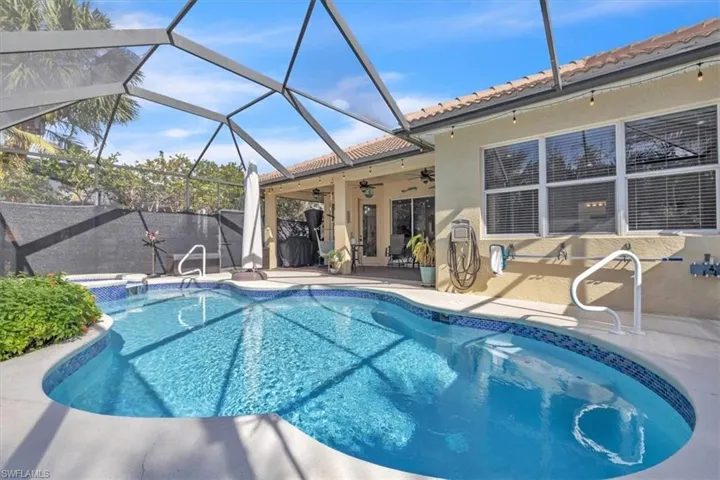View of swimming pool with patio surround, a sunroom, and glass enclosure