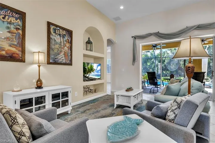 Living area featuring built in features, a sunroom, recessed lighting, arched walkways, and tile patterned flooring