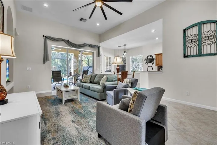 Living room with a sunroom, a ceiling fan, recessed lighting, and tile patterned flooring