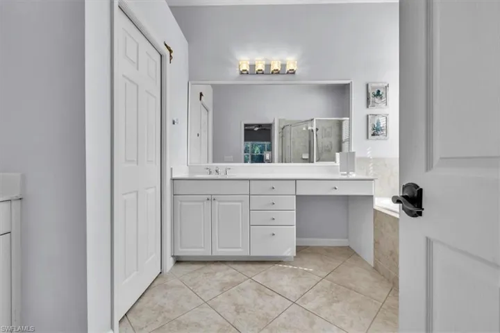 Full bath with a shower stall, vanity, a garden tub, and light tile patterned floors