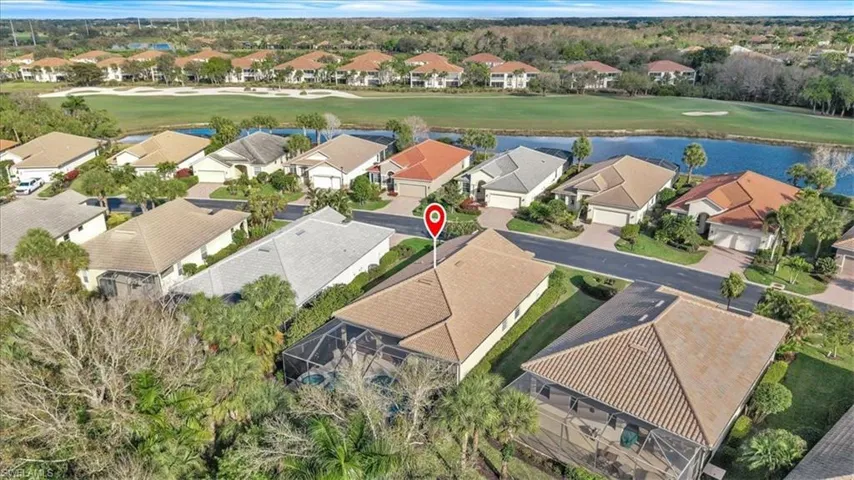 Aerial view of residential area with a nearby body of water and a local golf course