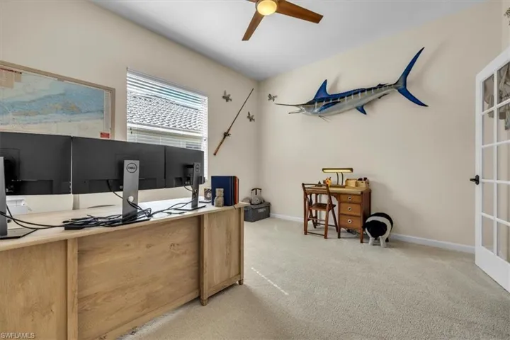 Office area with light carpet and ceiling fan