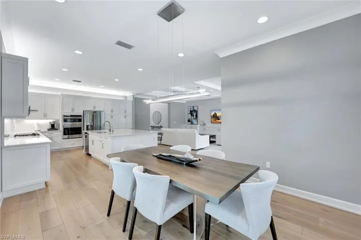 Dining space with recessed lighting, light wood-type flooring, visible vents, and crown molding
