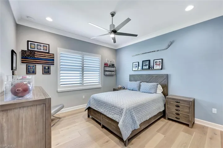 Bedroom with recessed lighting, light wood-type flooring, baseboards, and crown molding