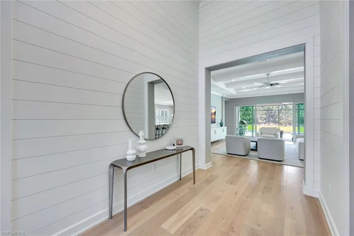 Corridor with light wood-type flooring and baseboards