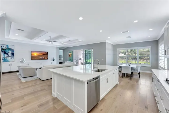 Kitchen with dishwasher, light wood-style flooring, a kitchen island with sink, and a sink