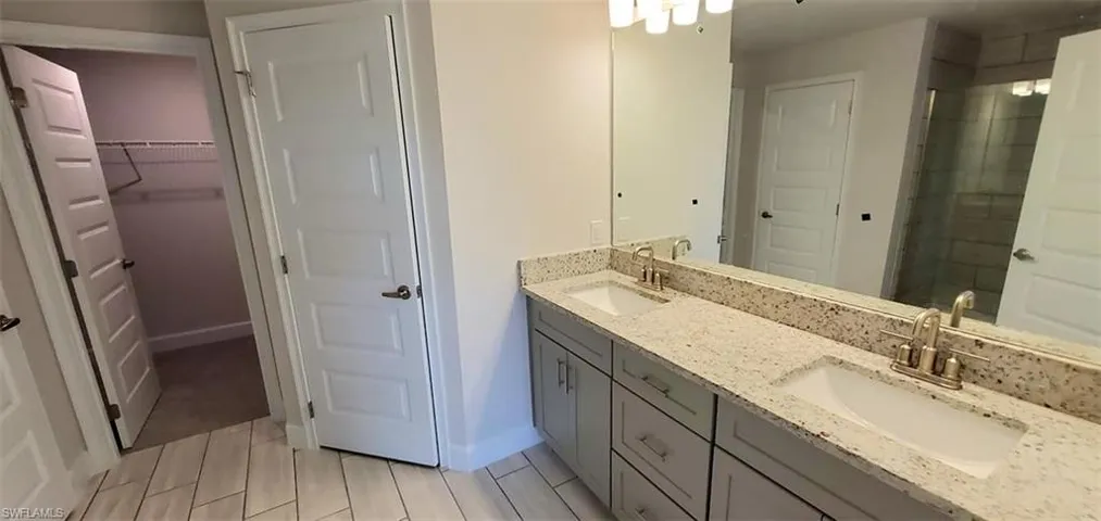 Primary Bathroom with tile patterned floors and double sink vanity