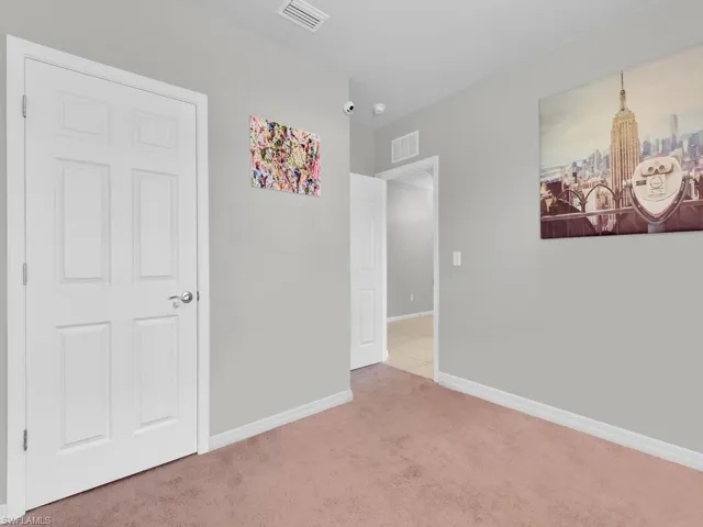 Unfurnished bedroom with visible vents, baseboards, and carpet