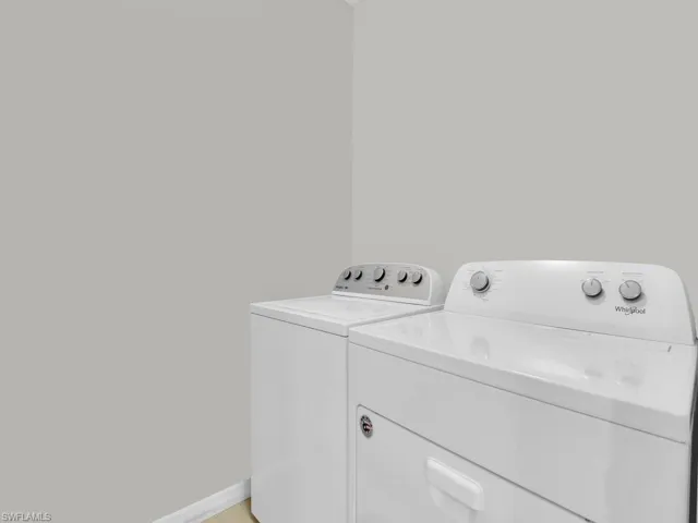 Washroom featuring laundry area, washing machine and dryer, and baseboards