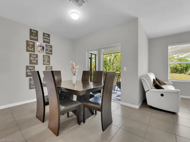 Dining area with light tile patterned floors, visible vents, and baseboards
