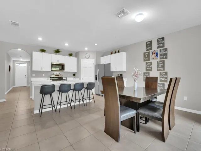 Dining area with arched walkways, visible vents, recessed lighting, and baseboards