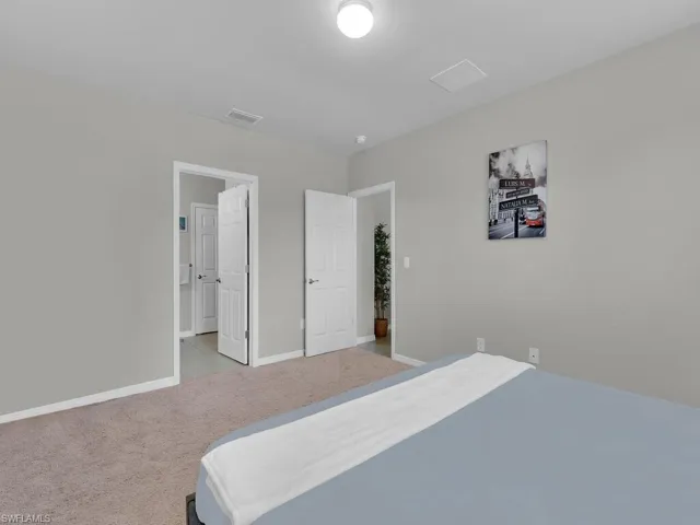 Bedroom with visible vents, baseboards, and carpet