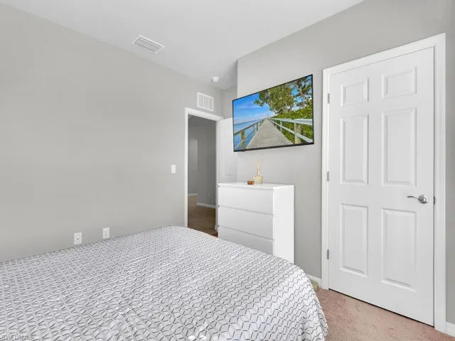 Carpeted bedroom with visible vents and baseboards