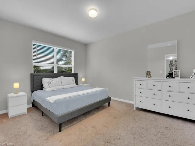 Bedroom with baseboards and light carpet