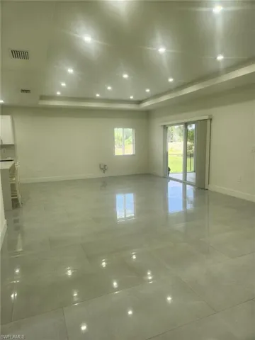 Empty room featuring baseboards and a tray ceiling