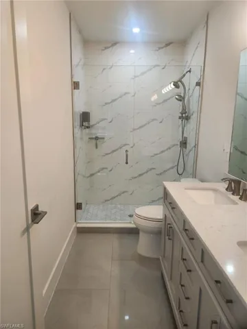 Full bathroom with a marble finish shower and double vanity