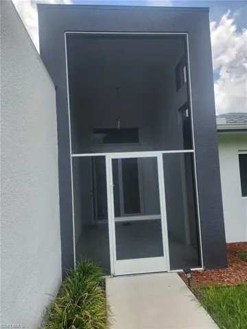 View of exterior entry with stucco siding