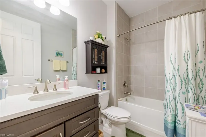 Full bathroom featuring vanity, shower / tub combo with curtain, and light tile patterned floors