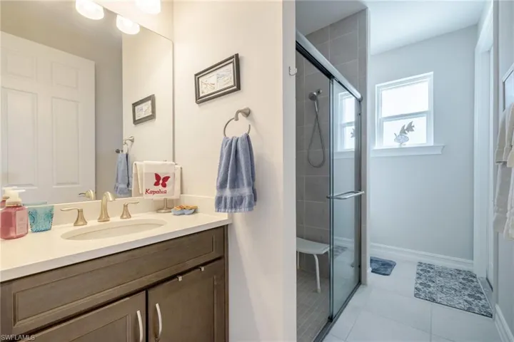 Bathroom with vanity, a stall shower, and light tile patterned floors