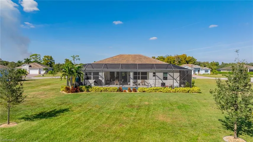 Rear view of house with a sunroom, glass enclosure, and a lawn