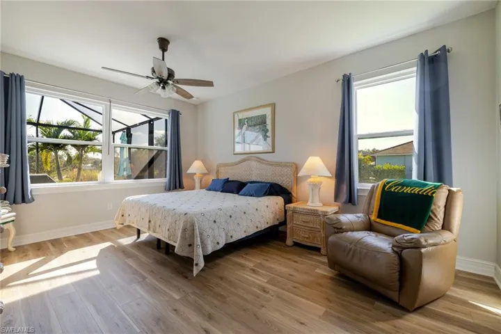 Bedroom featuring wood finished floors, ceiling fan, and multiple windows