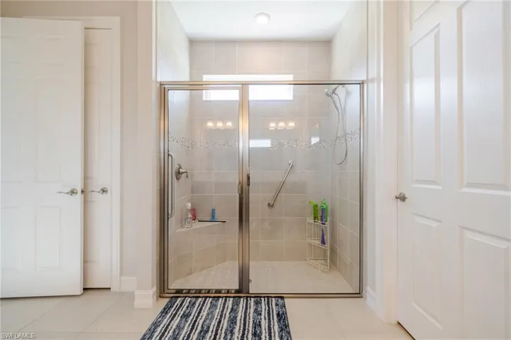 Full bathroom with light tile patterned floors and a stall shower