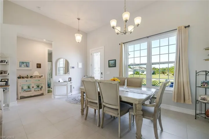 Dining room with light tile patterned flooring and a chandelier