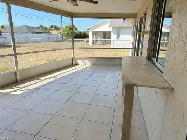 Unfurnished sunroom with ceiling fan and plenty of natural light