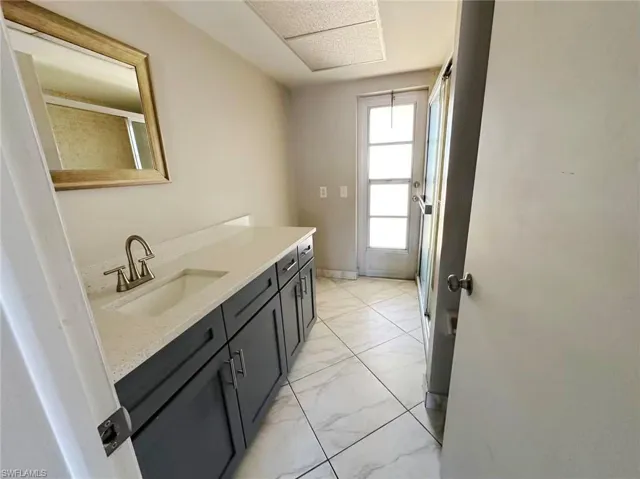 Bathroom featuring vanity, a shower stall, and light marble finish floors