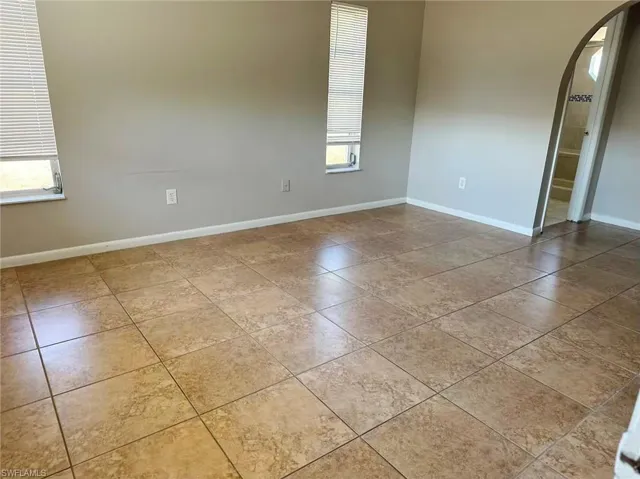 Spare room with arched walkways and light tile patterned floors