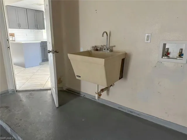 Laundry room featuring concrete flooring and washer hookup
