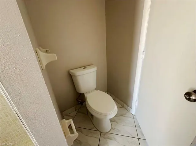Bathroom with toilet and light marble finish flooring