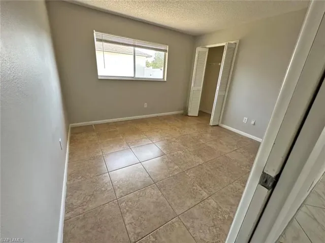 Unfurnished bedroom with a closet and a textured ceiling