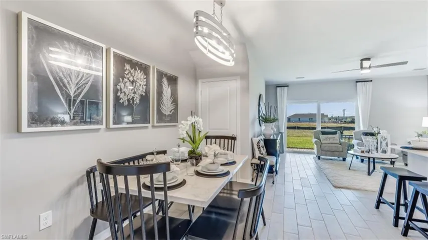 Dining space with ceiling fan with notable chandelier