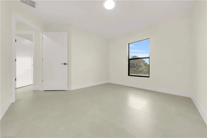 Empty room featuring baseboards and finished concrete flooring