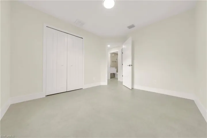 Unfurnished bedroom with concrete floors and a closet