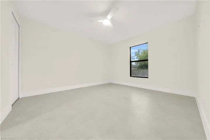 Unfurnished bedroom with a closet, finished concrete floors, and a ceiling fan