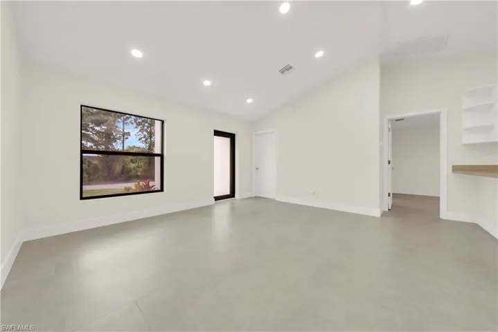 Unfurnished room with recessed lighting and high vaulted ceiling