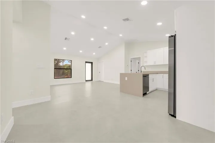 Unfurnished living room featuring recessed lighting, finished concrete flooring, and high vaulted ceiling