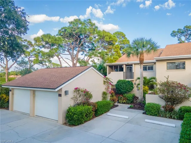 View of front of property featuring one-car garage and parking