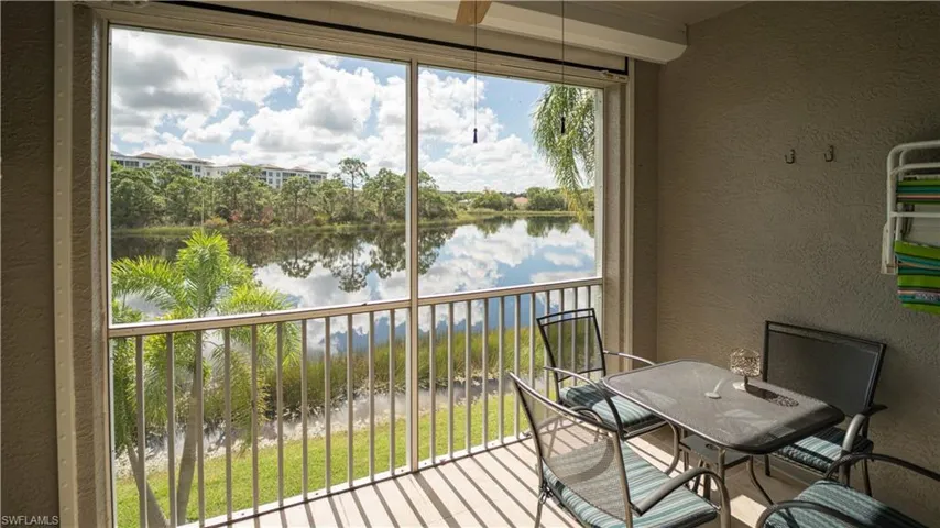 Balcony featuring a sunroom and a water view