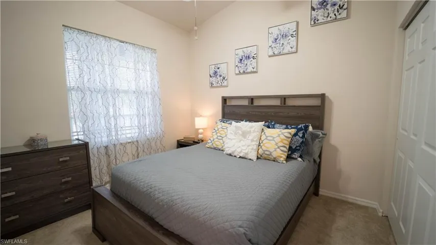 Bedroom featuring light carpet and a closet