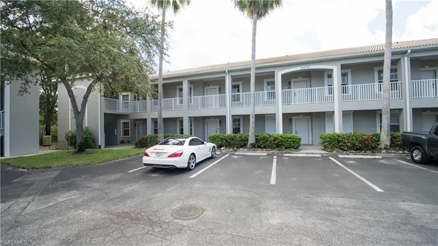 View of building exterior with uncovered parking