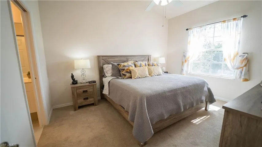 Bedroom featuring carpet floors, ceiling fan, and ensuite bathroom