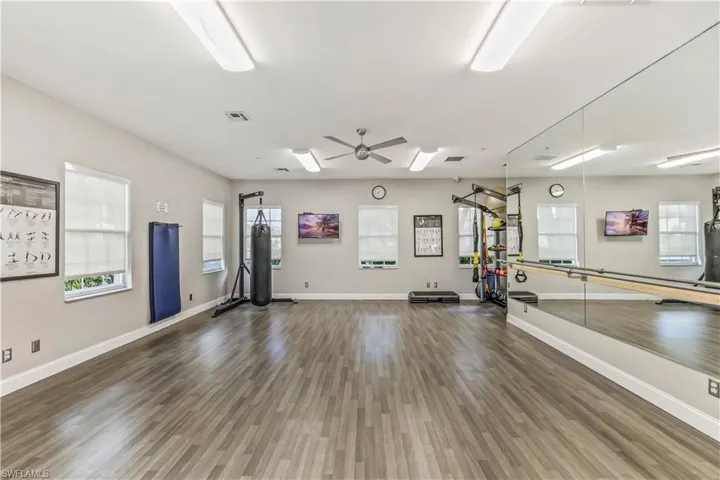 Workout room with dark hardwood / wood-style floors and ceiling fan