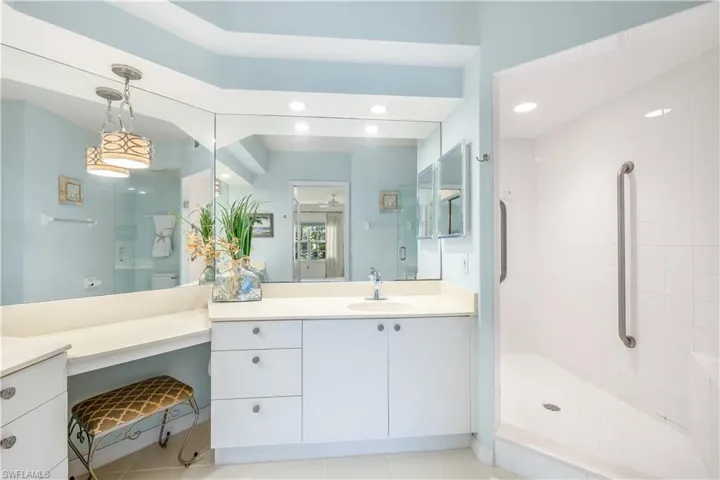 Master Bath featuring tile floors, walk-in tiled shower, and dual vanities