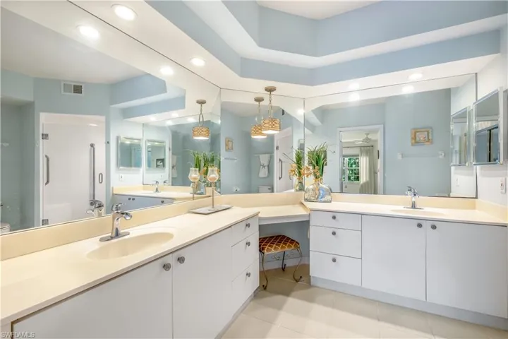 Master Bath featuring tile floors, walk-in tiled shower, and dual vanities