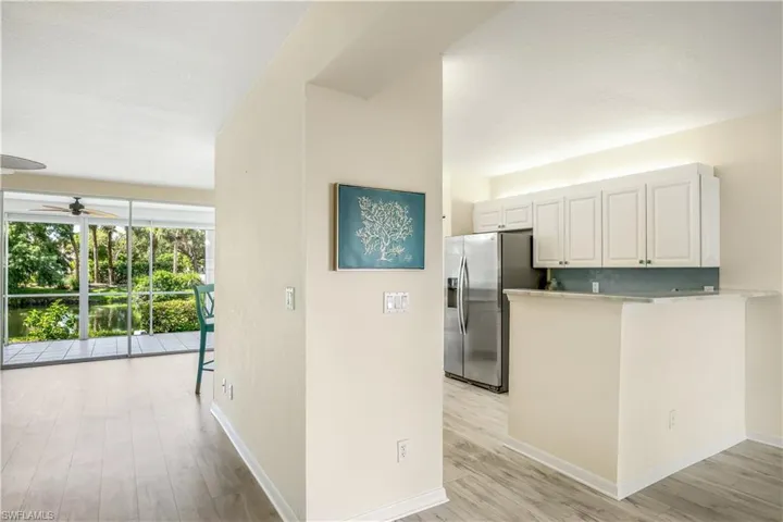 Kitchen with tasteful backsplash, ceiling fan, white cabinets, new LTV flooring, and stainless steel fridge