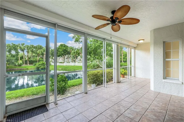 Screened Lanai/Sunroom featuring tiled floors, water view, ceiling fan, and pull down storm shutters