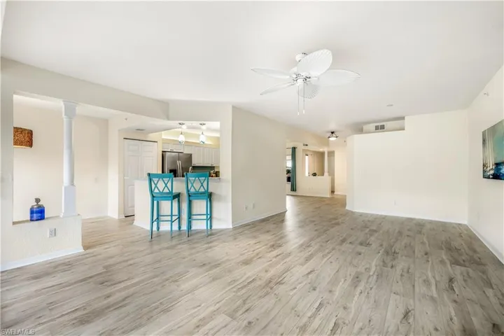 Living room with ornate columns, new LTV flooring, and ceiling fan